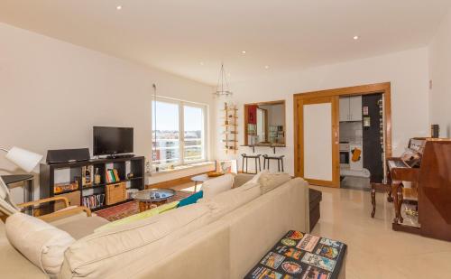 a living room with a couch and a tv at Eco Apartment @ Torre Verde (Green Tower) in Lisbon