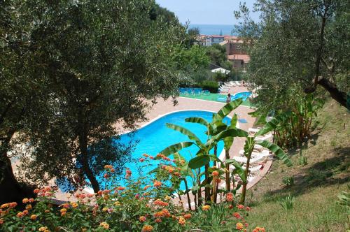 a swimming pool in a resort with trees and flowers at Residence Belvedere in Ascea