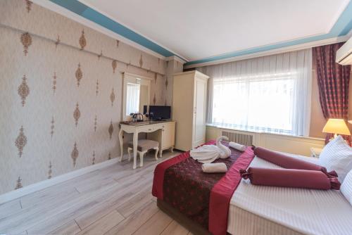 فندق فيفا ديلوكس في إسطنبول: غرفة نوم فيها سرير ومكتب