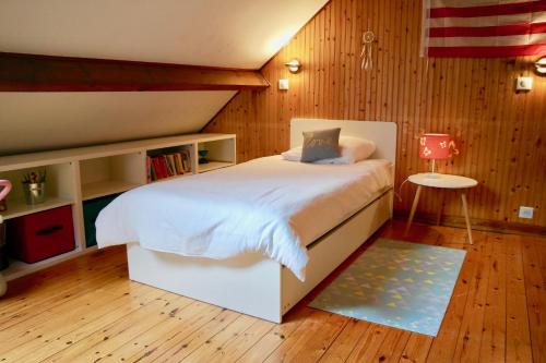 Schlafzimmer mit einem weißen Bett und Holzwänden in der Unterkunft Coup de coeur assuré pour cette charmante maison à 400 m de la plage in Saint-Gilles-Croix-de-Vie