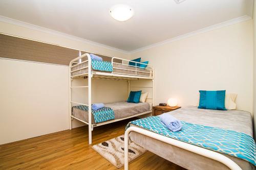 a bedroom with two beds and a bunk bed at Busselton Holiday Home in Busselton