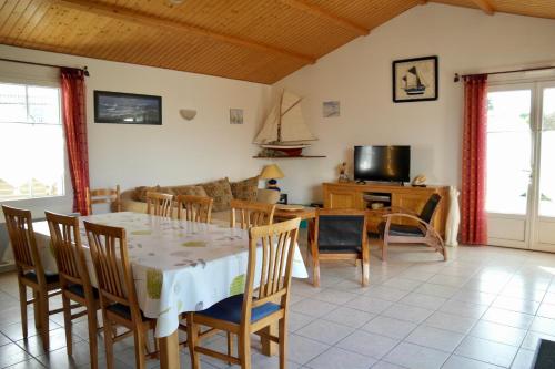 La Guérinière的住宿－Maison idéale pour des vacances au cœur de l’Ile de Noirmoutier，用餐室以及带桌椅的起居室。