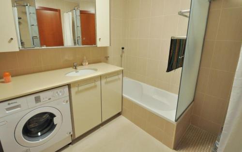 y baño con lavadora y lavamanos. en Ria Formosa, en Albufeira