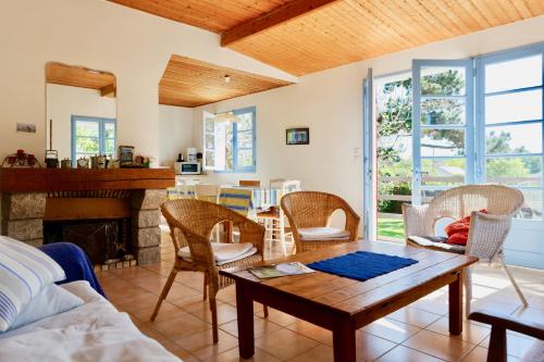 un salon avec une table et une cheminée dans l'établissement Maison de vacances à 2 pas de la plage du Portmain, à Pornic