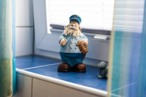 une figurine d'un chef assis sur un comptoir dans l'établissement Ferienhaus Strandperle, à Horumersiel