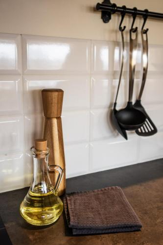 a kitchen counter with a bottle of oil and utensils at Liepaja Apartments in Liepāja