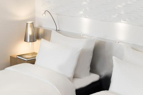 a white bed with white pillows and a lamp at Radisson Blu Scandinavia Hotel Aarhus in Aarhus