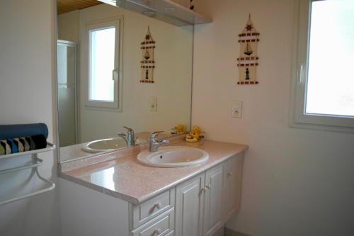 un bagno con due lavandini e un grande specchio di Maison idéale pour des vacances au cœur de l’Ile de Noirmoutier a La Guérinière