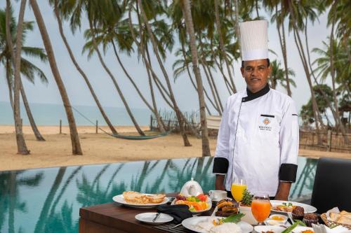 a chef standing in front of a table with food at Serendivi Resort Villa in Tangalle