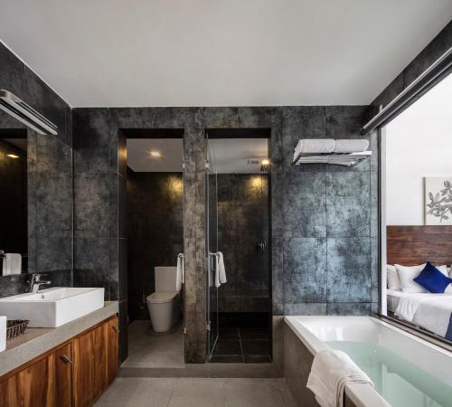 a bathroom with a tub and a sink at Serendivi Resort Villa in Tangalle
