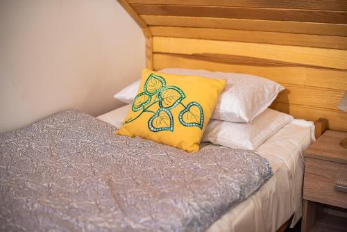 a bed with a yellow pillow on top of it at Holiday Home Mirt with HotTub & Sauna in Blanca
