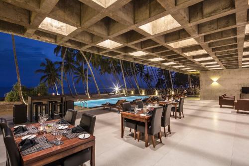 a dining room with a pool in the background at Serendivi Resort Villa in Tangalle