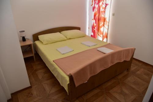 a bedroom with a bed with two pillows on it at Apartments Ivka in Malinska