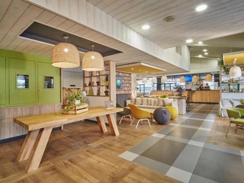 un hall avec une table et des chaises dans un magasin dans l'établissement Campanile Poitiers - Site du Futuroscope, à Chasseneuil-du-Poitou