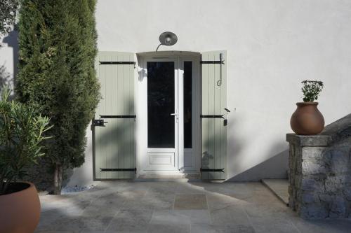 uma porta para uma casa com um vaso ao lado em Maison Les Costes em Vernègues