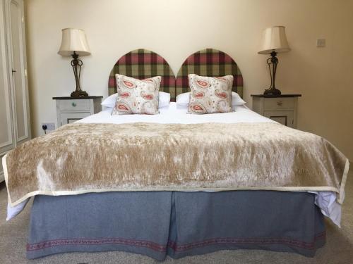 a bedroom with a large bed with two lamps at Eden's House in Hexham
