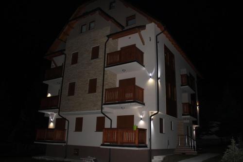 un edificio con balconi ai lati di notte di Apartman Goca a Zlatibor