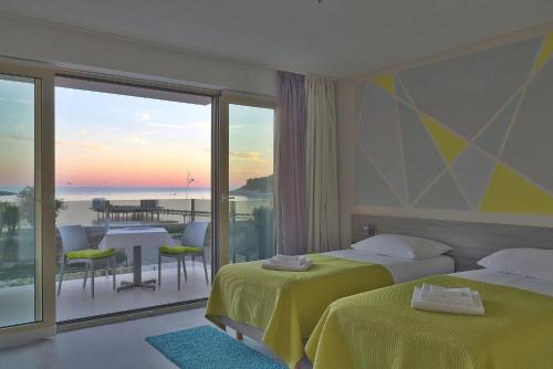 a hotel room with two beds and a balcony at Hotel Modo in Pula
