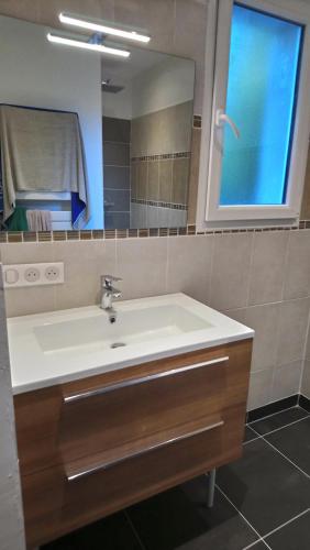 une salle de bain avec un lavabo et un miroir dans l'établissement Un style balnéaire moderne à 300 mètres de la mer, à Pornichet