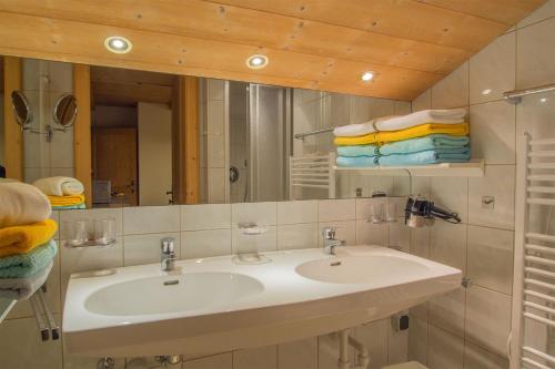 a bathroom with a sink and a mirror and towels at Seeappartements Überwasser in Ladis