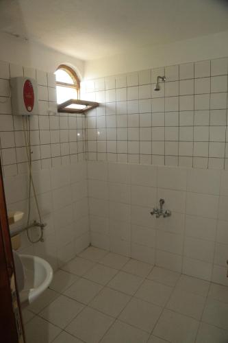 a bathroom with a shower and a tub and a window at Murat Hotel in Demre