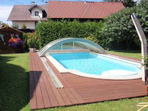 an above ground pool with a wooden deck and a swimming poolvisor at Ferienwohnungen Kern in Weyregg