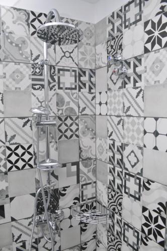 a bathroom with black and white tiles on a wall at Polymnia Apartments Lassi in Lassi