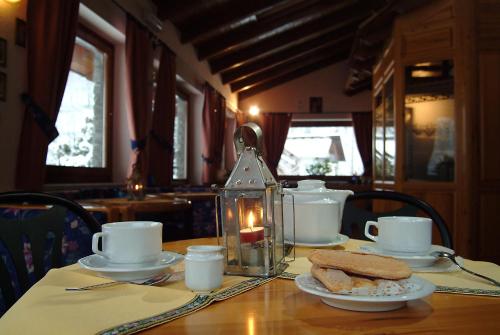 a table with a plate of food and a candle at Hotel Des Roses in Antey-Saint-André