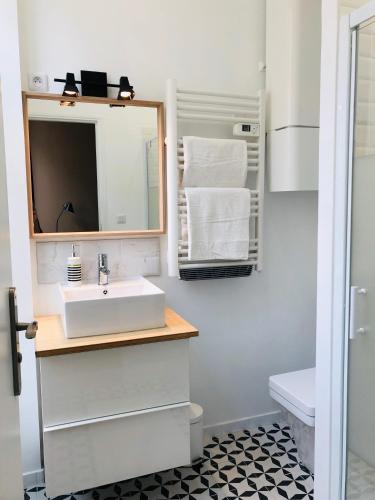 une salle de bain avec un lavabo et un miroir dans l'établissement Marseillement votre, à Marseille