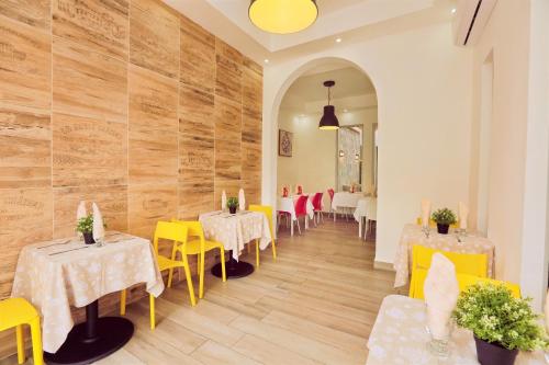 a dining room with tables and yellow and white chairs at RIG Puerto Malecón in Santo Domingo