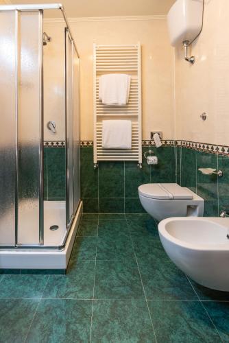 a bathroom with two sinks and a shower at Hotel Lido - Beach and Palace in Bolsena