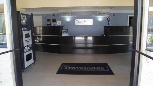 a store entrance with a refrigerator and a welcome mat at Travelodge by Wyndham North Richland Hills/Dallas/Ft Worth in North Richland Hills