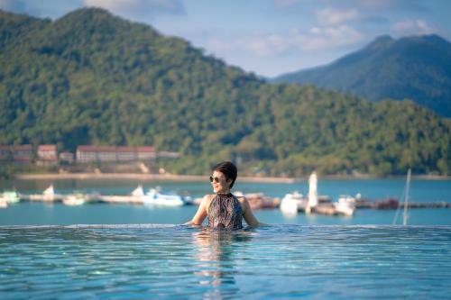 a woman is standing in the water in a lake at Bhuvarin Resort in Ko Chang