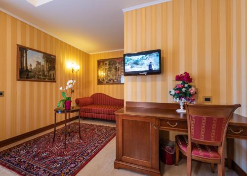 a living room with a tv and a red couch at Hotel Lido - Beach and Palace in Bolsena