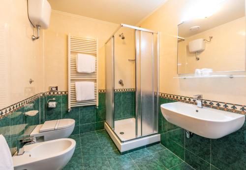 a bathroom with two sinks and a shower at Hotel Lido - Beach and Palace in Bolsena