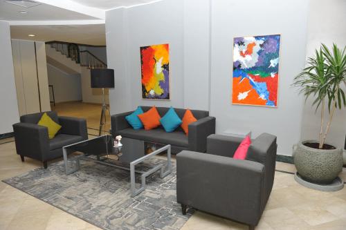 a living room with couches and paintings on the wall at Assiut Cement Hotel in Asyut