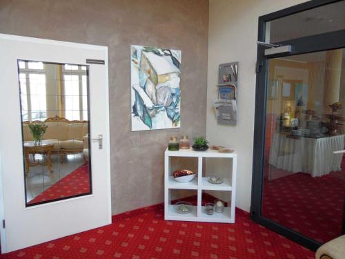 a room with a red carpet and a room with a table at Hotel Garni Arcis in Gomaringen