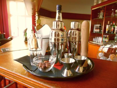 a tray with glasses and a bottle on a counter at Hotel Garni Arcis in Gomaringen