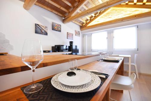 a kitchen with a table with wine glasses on it at Home Venice Apartments - Biennale 1 - 2 - 3 in Venice