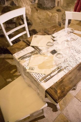 a wooden table with wine glasses and wine glasses at Il Cortiletto Hotel Maison in Tresnuraghes