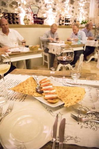 a table with a plate of food and glasses of wine at Il Cortiletto Hotel Maison in Tresnuraghes