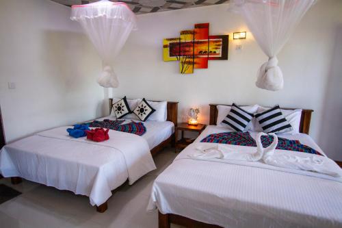 a bedroom with two beds with white sheets at Wood Heart in Ella