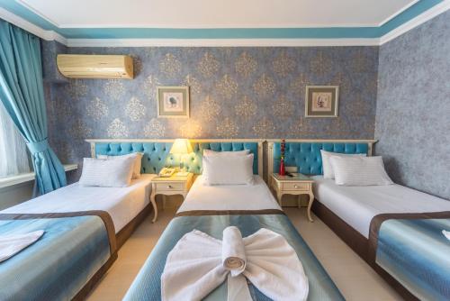 two beds in a room with blue walls at Viva Deluxe Hotel in Istanbul