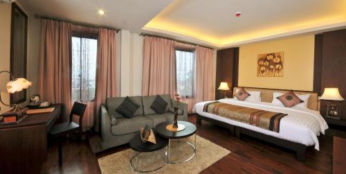 a hotel room with a bed and a couch at Salana Boutique Hotel in Vientiane