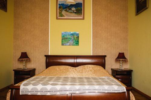 a bedroom with a bed with two nightstands and two lamps at Historical center in Uzhhorod