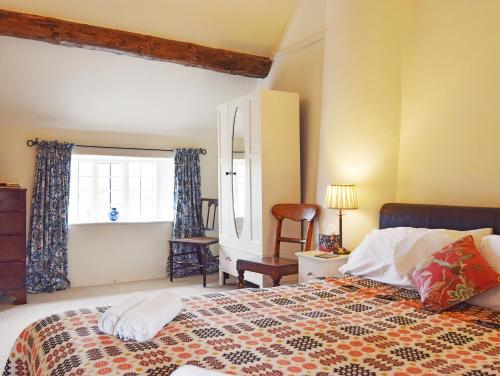 a bedroom with a bed and a window at Maisey Cottage in Lechlade