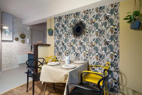 une salle à manger avec une table et des chaises jaunes dans l'établissement LE TOUCAN by Cocoonr, à Rennes