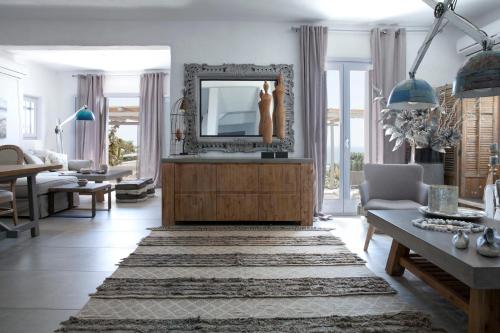 a living room with a mirror and a couch at Alfa Luxury Villas in Chrissi Akti