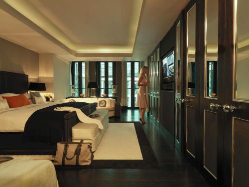 倫敦的住宿－Grosvenor House Suites，一位妇女站在卧室里,卧室里配有床
