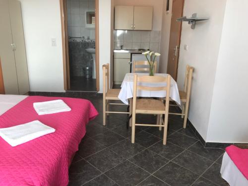 a room with a table and chairs and a kitchen at Apartments Radosevic in Ulcinj